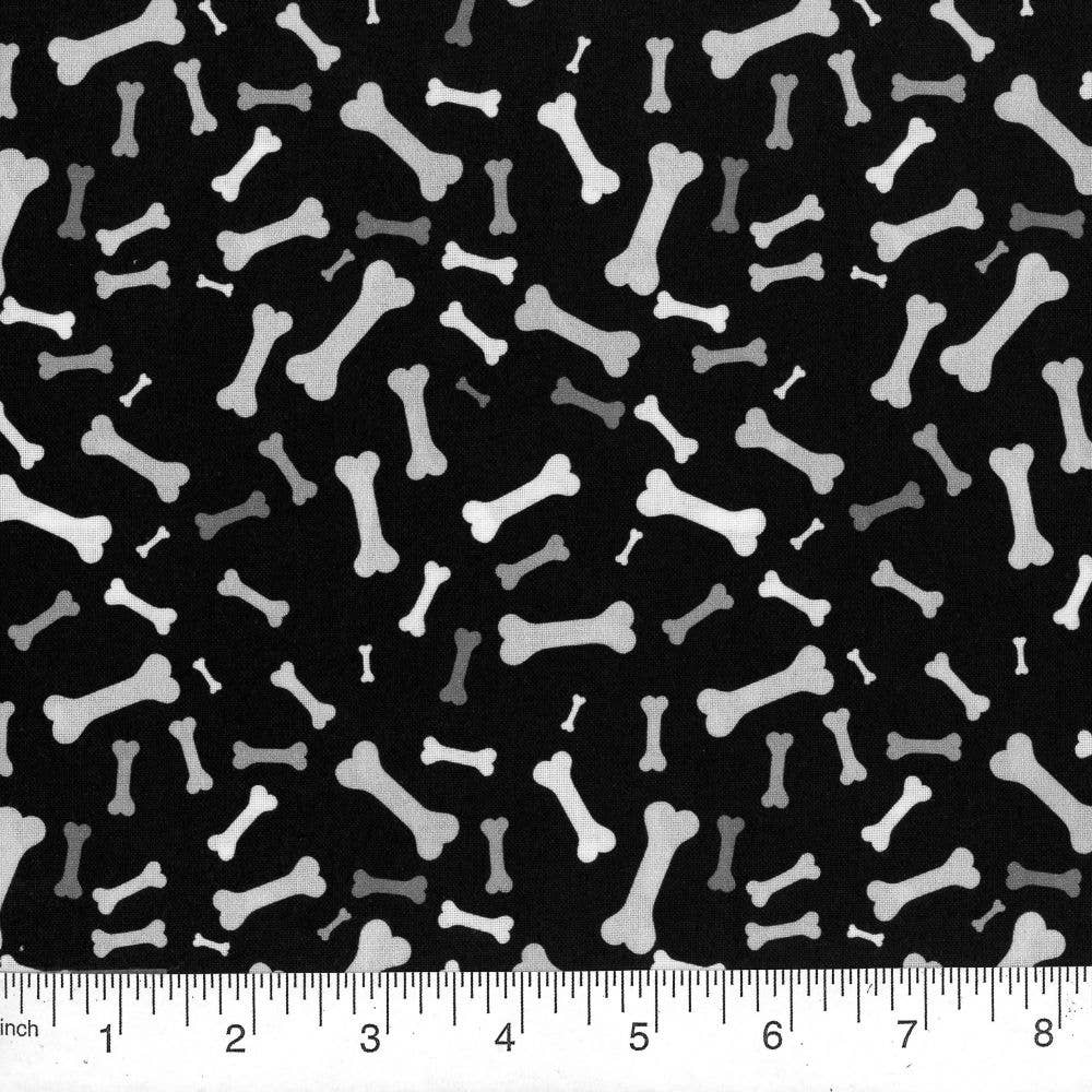 Pattern of white bones on a black background with a ruler at the bottom.