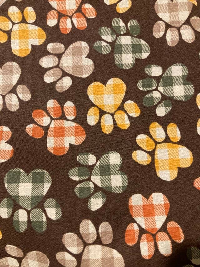 Pattern of plaid paw prints on a brown background