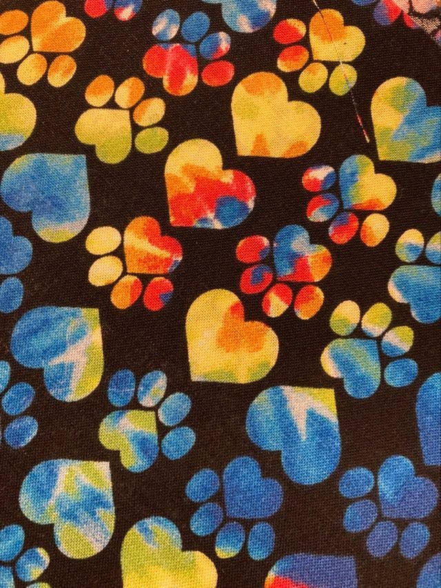 Colorful paw prints and heart shapes on a black background