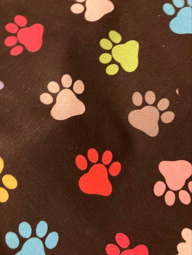 Pattern of colorful paw prints on a brown background