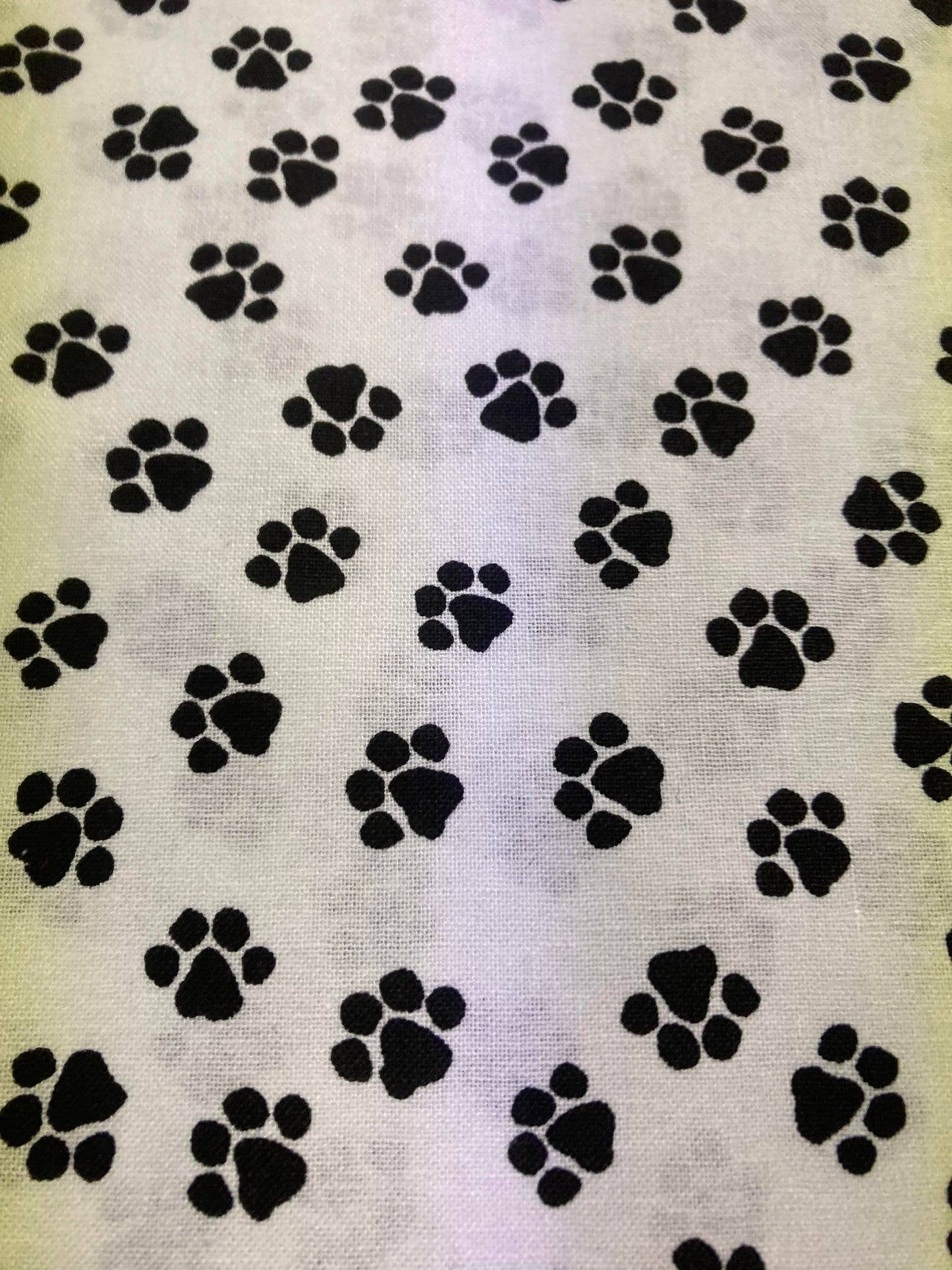 Pattern of black paw prints on a textured white background