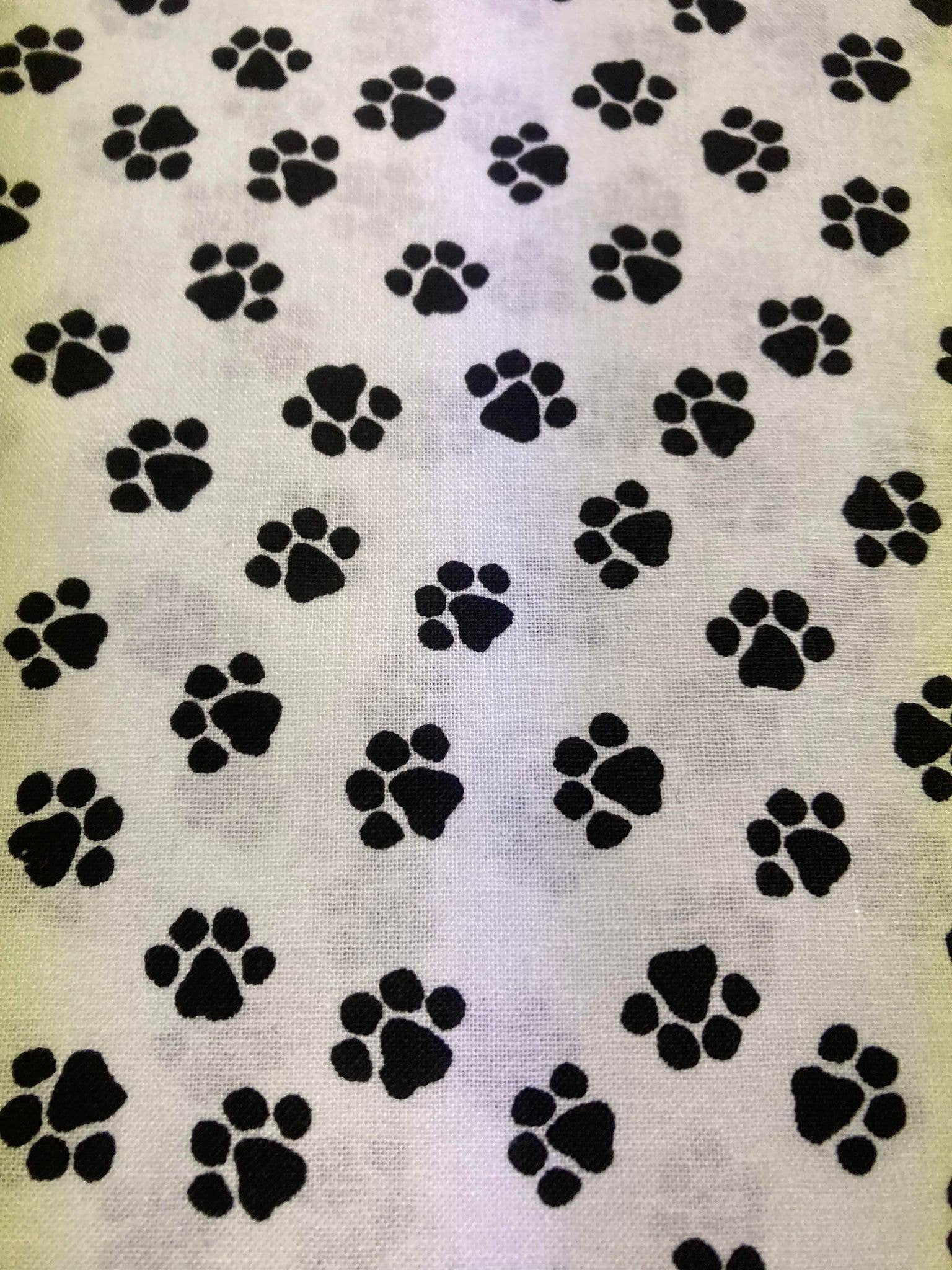 Pattern of black paw prints on a textured white background