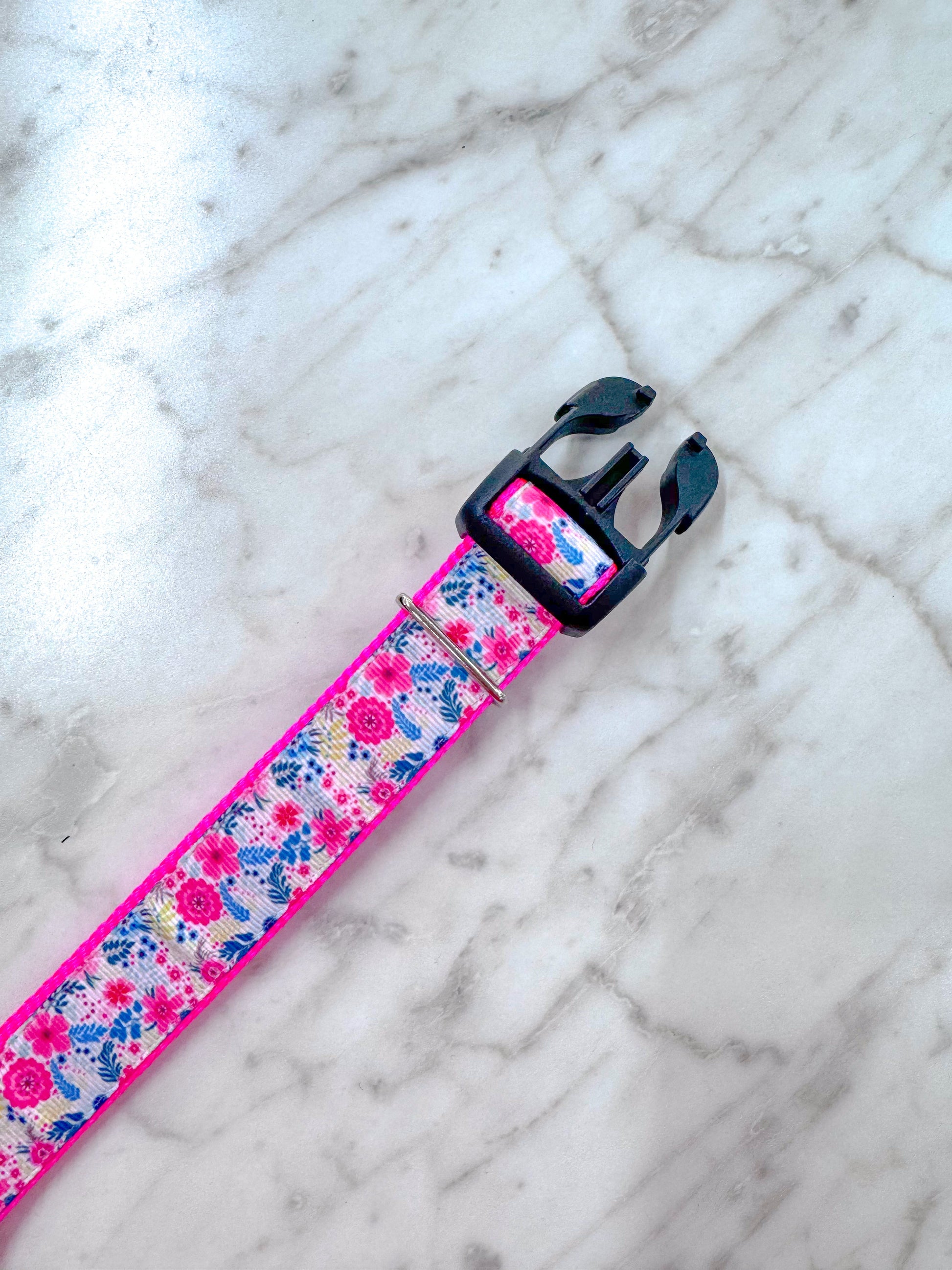 Floral-patterned dog collar on a marble surface