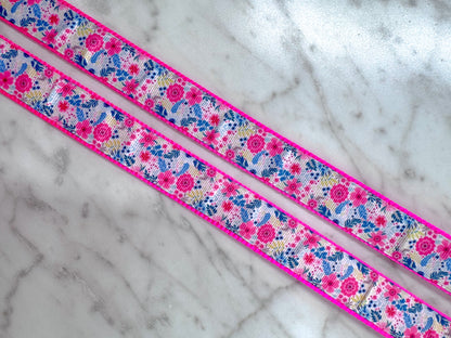 Floral ribbon with pink border on a marble surface