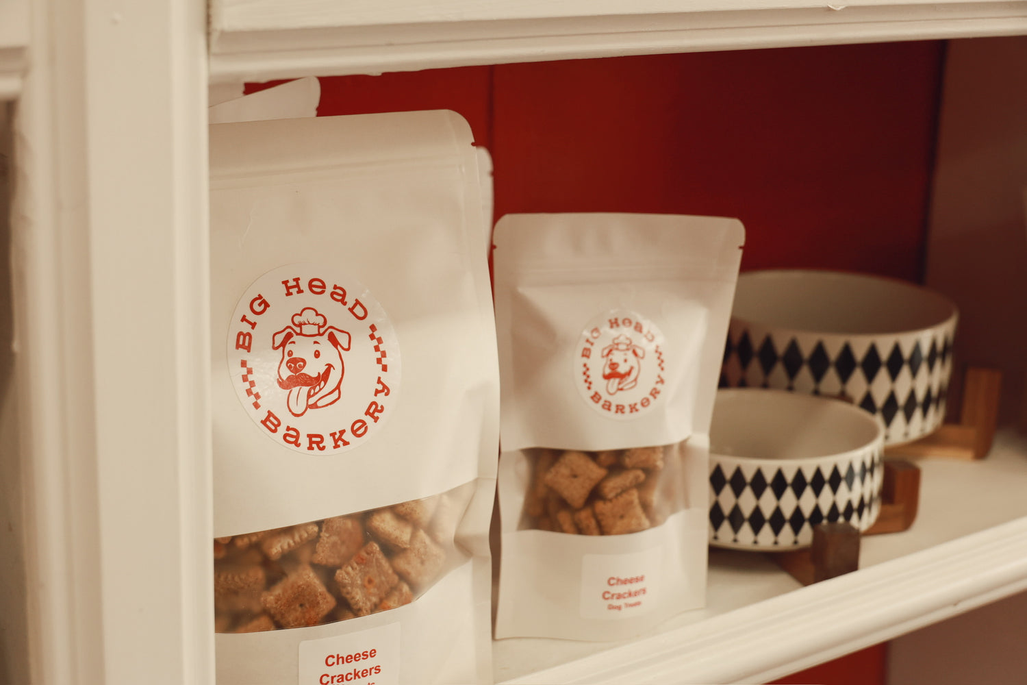 Dog treats packaging with 'Big Head Barker' branding on a shelf.