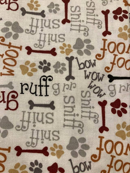 Fabric with dog-themed patterns including bones, paw prints, and text on a beige background