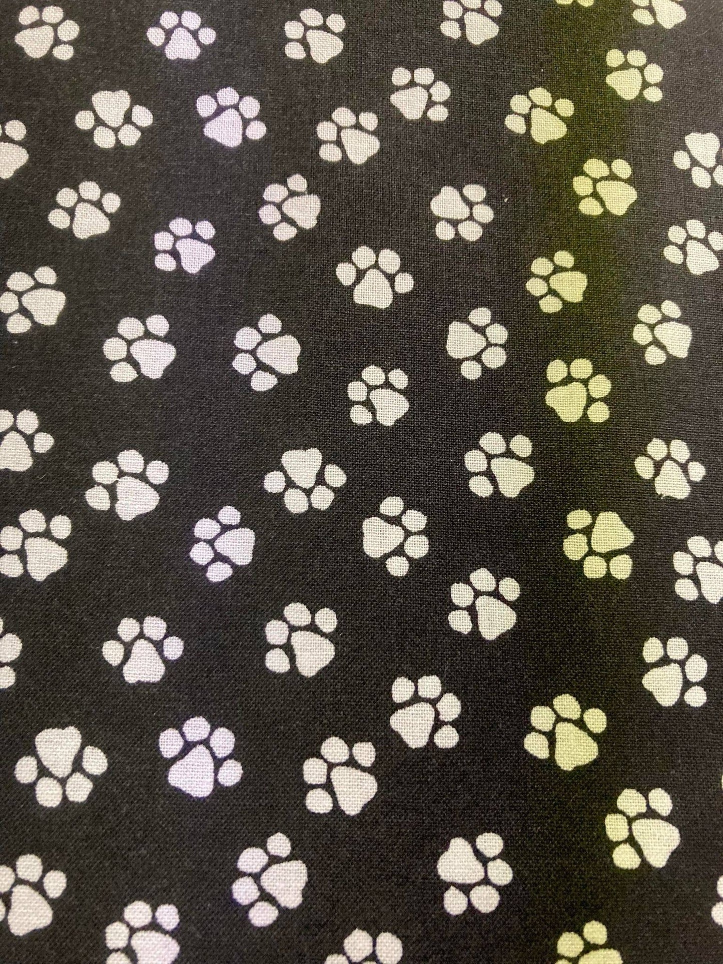 Pattern of paw prints in various colors on a black background
