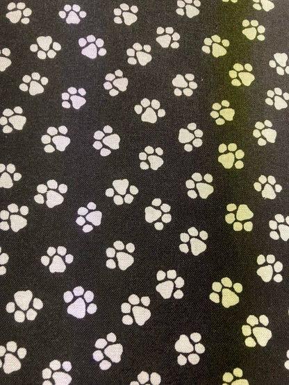 Pattern of paw prints in various colors on a black background