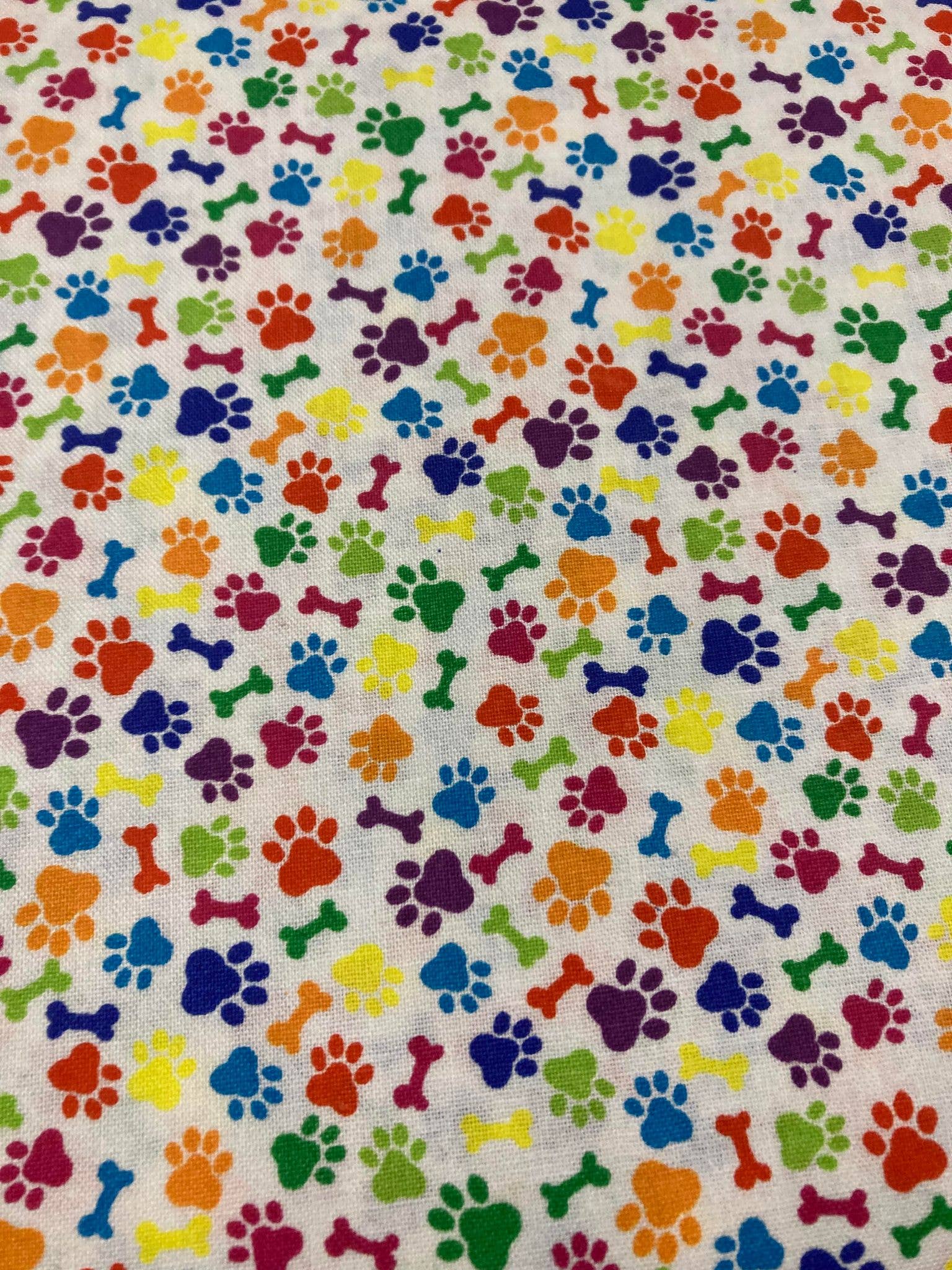 Colorful pattern of paw prints and bones on a fabric background