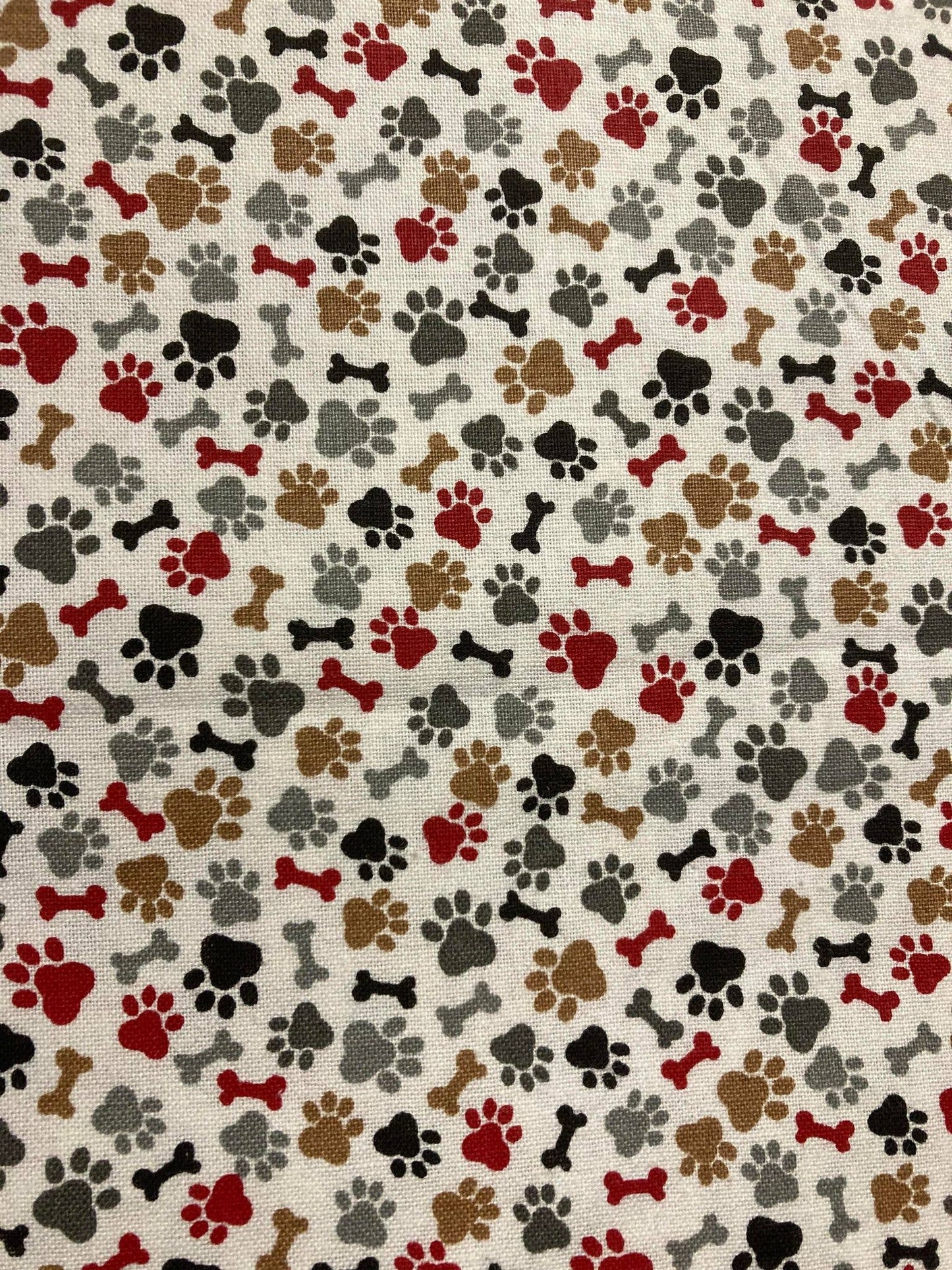 Pattern of dog paw prints and bones on a beige background